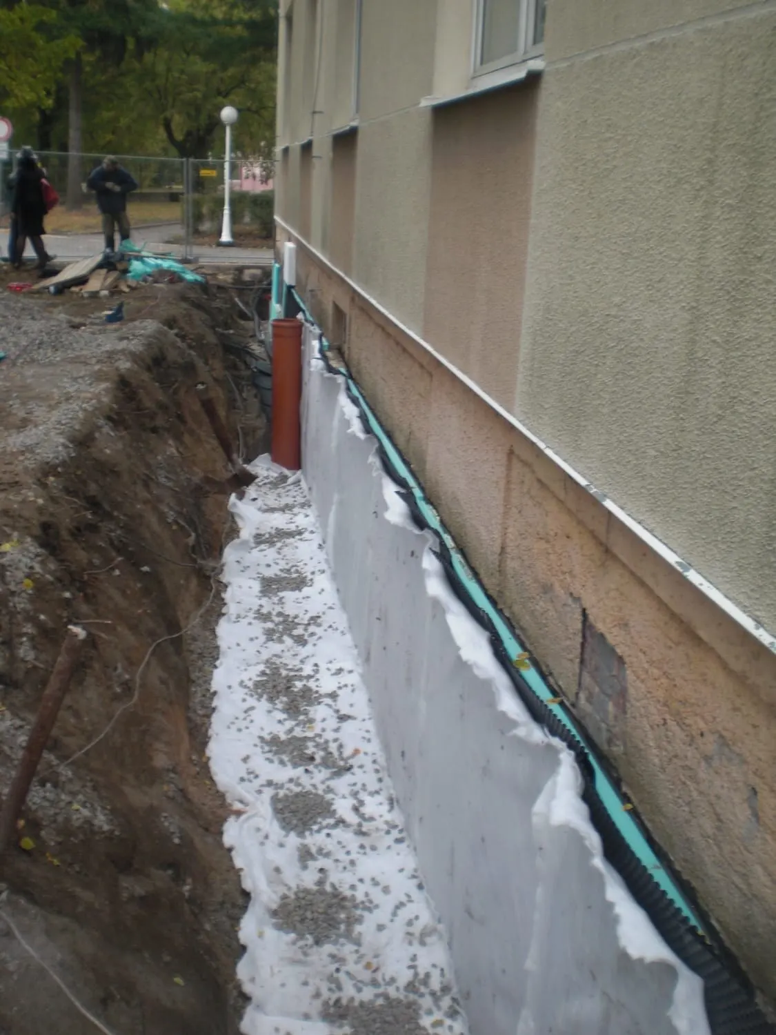 Odkopaná spodní stavba bytového domu s novou hydroizolací a drenáží