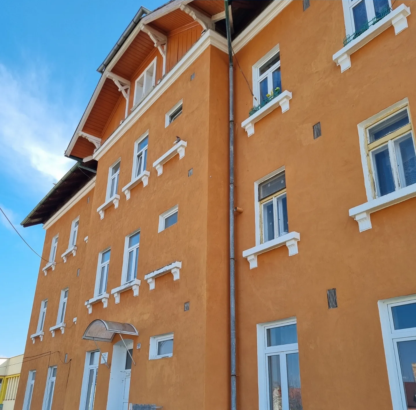 Opravená fasáda činžovního domu v jihočeském městě po dokončení prací